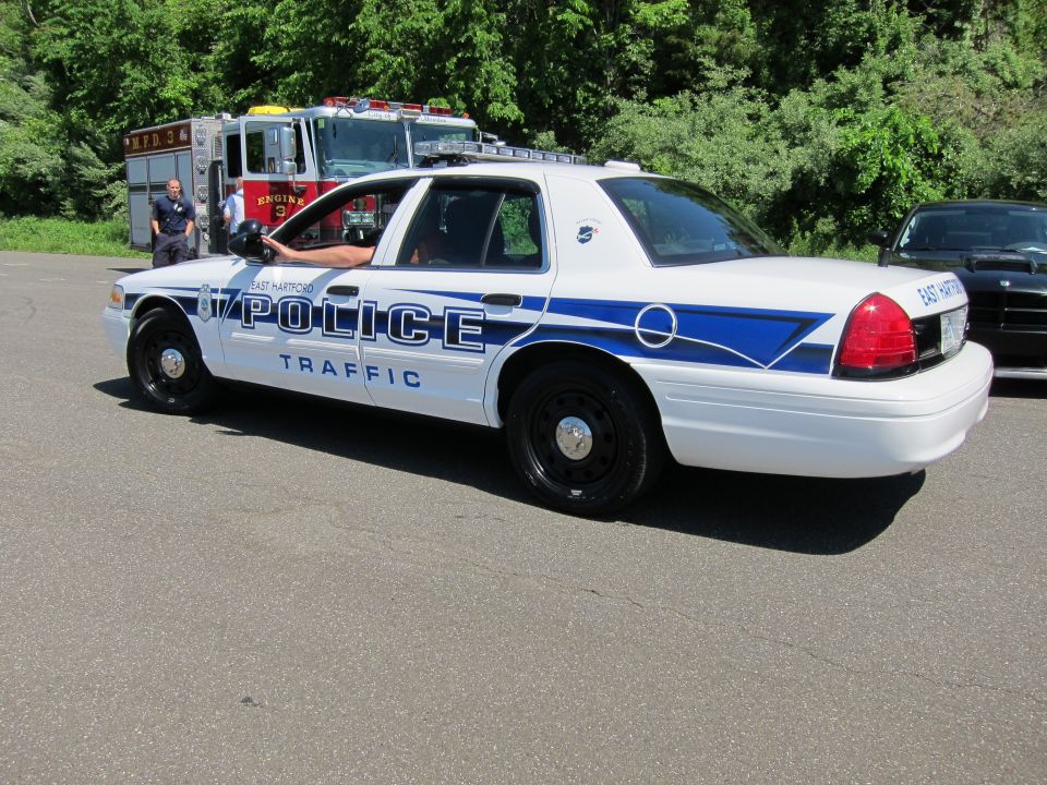 White Ford Crown Victoria lettered POLICE TRAFFIC, side view, with a fire truck behind