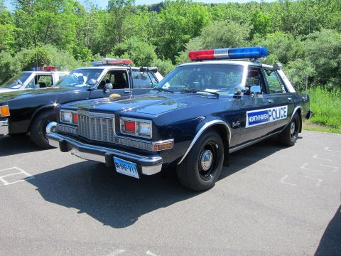 1991 Ford LTD Crown Victoria - dark-blue full-size Plymouth police sedan lettered NORTH HAVEN POLICE with roof light bar parked beside another cruiser.