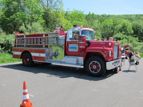 1991 Ford LTD Crown Victoria - red Mack fire engine pumper truck with chrome trim and a roof beacon parked on pavement with a traffic cone nearby.