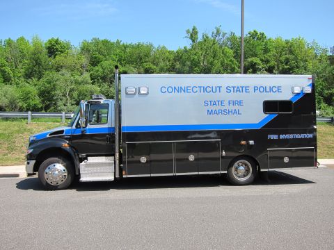 1991 Ford LTD Crown Victoria - black medium-duty box truck marked Connecticut State Police State Fire Marshal Fire Investigation, parked roadside in profile.