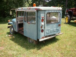 1978 Ford Bronco - This vintage Jeep panel truck, possibly a delivery vehicle, is seen outdoors with another piece of farm equipment in the background.