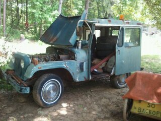 1978 Ford Bronco - This Jeep FC-150 truck is in a wooded area, showing its engine compartment and spare tires.