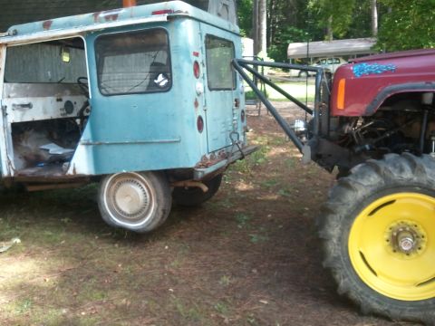 1978 Ford Bronco - A blue van is attached to a red tractor, both appearing to be in a state of disrepair.