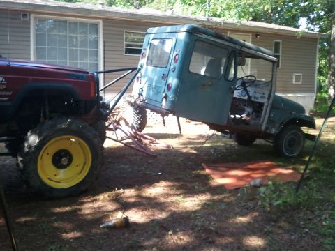 1978 Ford Bronco - Jeep Cherokee XJ tows a blue Jeep CJ-5 body, modified for off-road use.