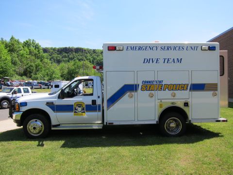 1991 Ford LTD Crown Victoria - white Ford box truck lettered Connecticut State Police Emergency Services Unit Dive Team, parked in profile on grass.