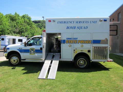 1991 Ford LTD Crown Victoria - Side view of a white Connecticut State Police Emergency Services Unit Bomb Squad truck with its rear ramp down on grass.