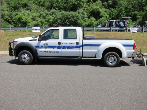 1991 Ford LTD Crown Victoria - white Hartford Police Traffic Division extended-cab pickup with a blue stripe, parked in profile on a paved lot.