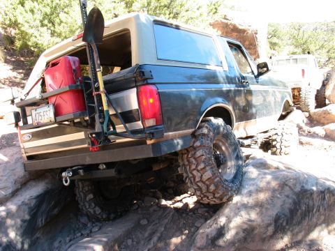 1994 Ford Bronco - A modified Ford Bronco tackles a rocky trail, equipped for off-road adventure.