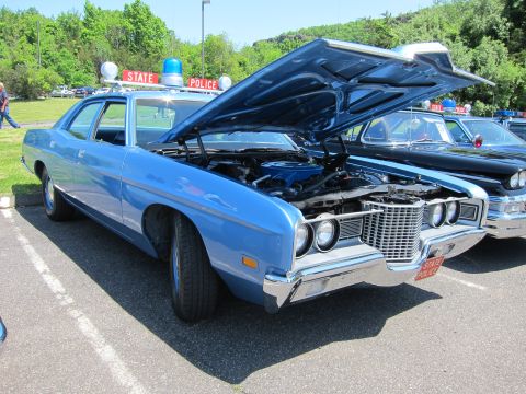 1991 Ford LTD Crown Victoria - blue 1970s Ford State Police sedan with its hood raised to show the engine, twin roof lights and a State Police roof sign.