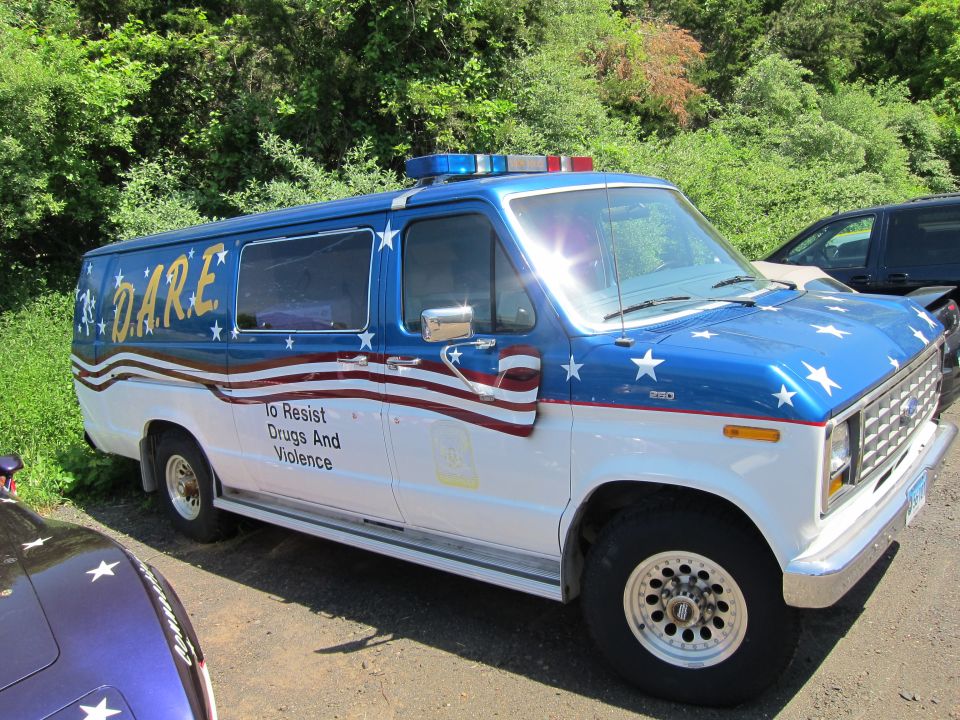Side of blue and white D.A.R.E. Ford van with stars-and-stripes graphics