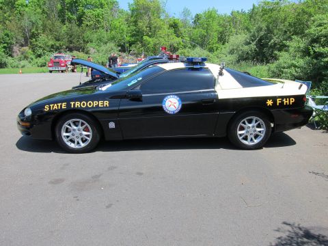 1991 Ford LTD Crown Victoria - Side view of a black and tan Chevrolet Camaro lettered STATE TROOPER and FHP with a Florida-style door seal and roof lights.