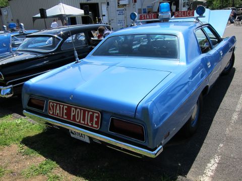 1991 Ford LTD Crown Victoria - Rear three-quarter of a light blue 1970s coupe with a STATE POLICE rear plate and roof light bar at an outdoor show.