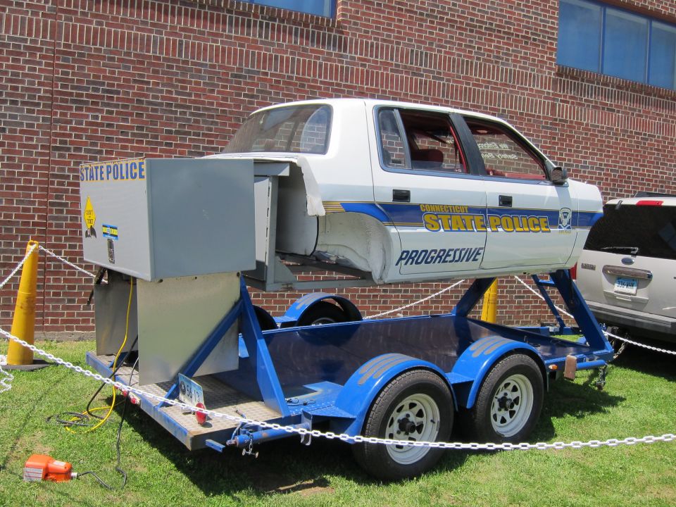 Rear view of Connecticut State Police rollover simulator car on blue trailer
