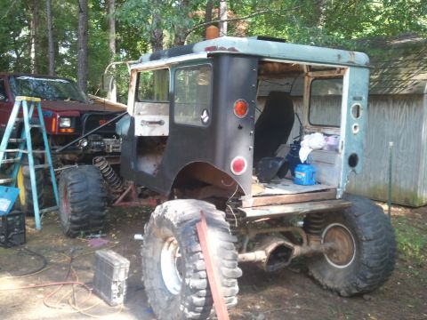 1978 Ford Bronco - This heavily modified off-road vehicle appears to be undergoing extensive work, with a second vehicle visible in the background.