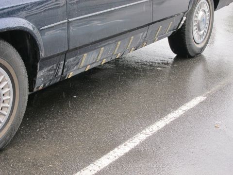 1991 Ford Crown Victoria LTD - Side view of a car's lower body panel with visible damage and attached trim pieces.
