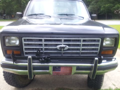 1986 Ford Bronco - Front view of a dark gray Ford Bronco, showing its grille and bumper details.
