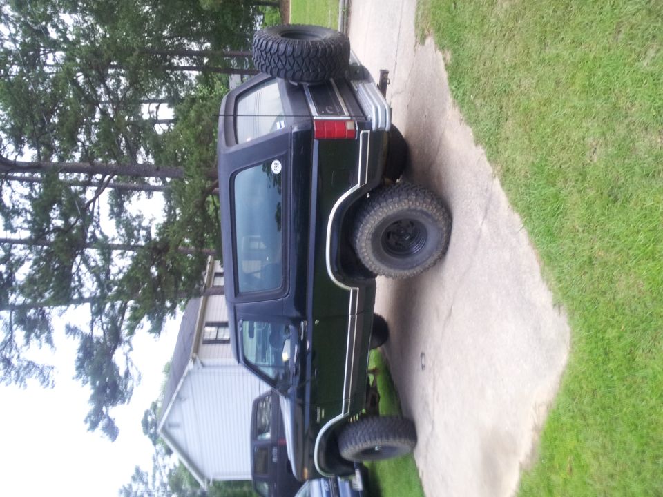 Black SUV, 3q-front view, with spare tire mounted on the rear