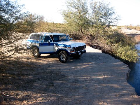 1979 Ford Bronco - 1979 Ford Bronco parked on a dirt bank overlooking a body of water.