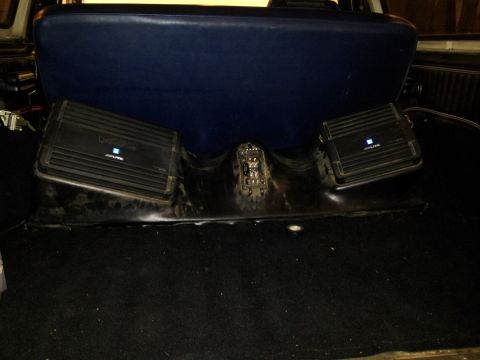 1979 Ford Bronco - Two Alpine car amplifiers are visible in the rear interior of a vehicle, mounted behind the seat.