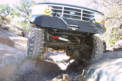 1994 Ford Bronco - Ford Bronco navigating rocky terrain with large off-road tires and a winch.