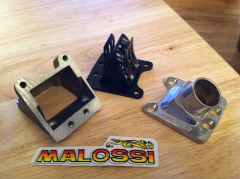 1981 Garelli Rally Sport - Motorcycle engine parts, including a reed valve assembly and intake manifold, are displayed with a Malossi sticker.