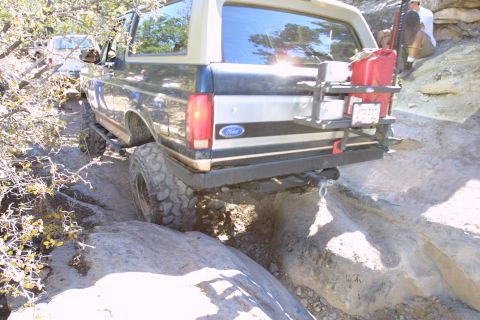 1994 Ford Bronco - A Ford Bronco navigates a challenging off-road path, with another vehicle visible in the background.