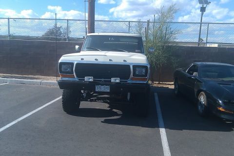 1979 Ford Bronco - Front view of a white 1979 Ford Bronco parked next to a black sports car. The license plate reads 376-SHB.