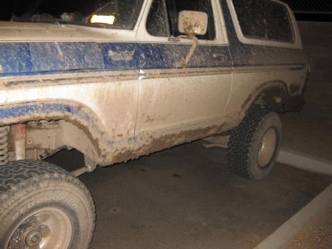1979 Ford Bronco - This SUV is covered in mud, showing its side profile and off-road tires.