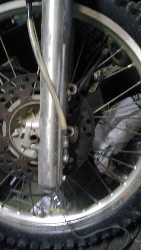 1989 Ford Bronco - Motorcycle front wheel assembly with brake disc and suspension fork visible.
