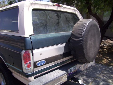 1993 Ford Bronco - The rear of a 1993 Ford Bronco shows its iconic spare tire carrier and taillight assembly.
