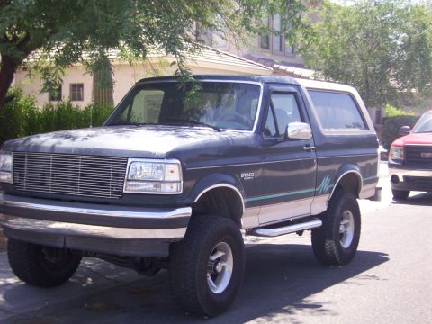 1993 Ford Bronco - This lifted 1993 Ford Bronco features a two-tone paint scheme with a dark blue body and a white removable top.