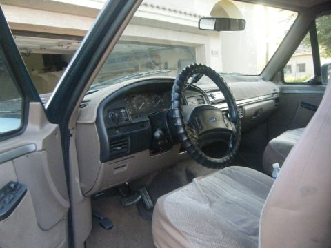 1993 Ford Bronco - The interior of a 1992 Ford Bronco is visible, with a tan dashboard and seats.