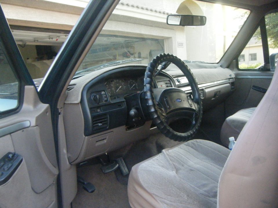 Tan interior of a 1992 Ford Bronco, showing the dashboard, steering wheel, and seats