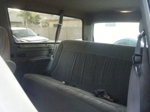 1993 Ford Bronco - The interior of a 1993 Ford Bronco, the rear bench seat and a view of the outside.