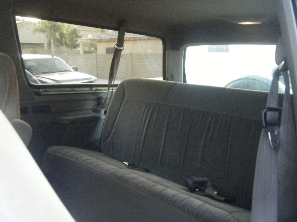 Interior view of a 1993 Ford Bronco, showing the rear bench seat and a glimpse of the exterior through the windows