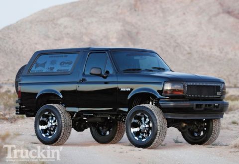 1993 Ford Bronco - This modified Ford Bronco features a custom grille and wheels, with a lifted suspension and a spare tire mounted on the rear.