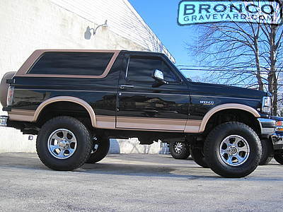 1993 Ford Bronco - This black Ford Bronco features a two-tone tan trim and is equipped with a lifted suspension and chrome wheels.