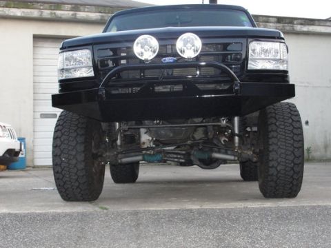 1993 Ford Bronco - Front view of a lifted black Ford Bronco with an aftermarket bumper and lights.