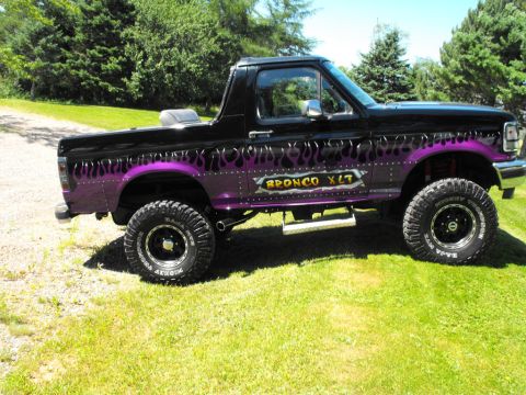 1993 Ford Bronco - This modified Ford Bronco XLT features custom purple flame graphics and large off-road tires.