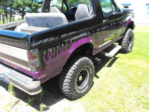 1993 Ford Bronco - This 1993 Ford Bronco features custom purple flame graphics on its black paint.