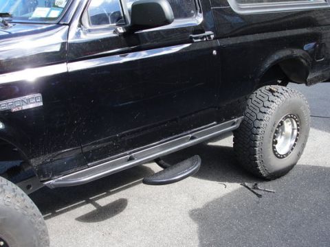 1993 Ford Bronco - This black 1993 Ford Bronco XLT features running boards and off-road tires, its side.