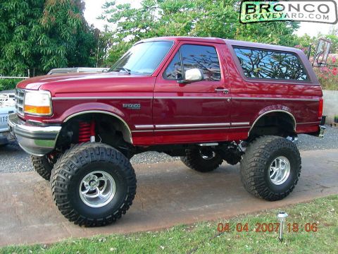 1993 Ford Bronco - Maroon Ford Bronco on a tall suspension lift with oversized tires and chrome wheels; Bronco Graveyard watermark, dated 2007.