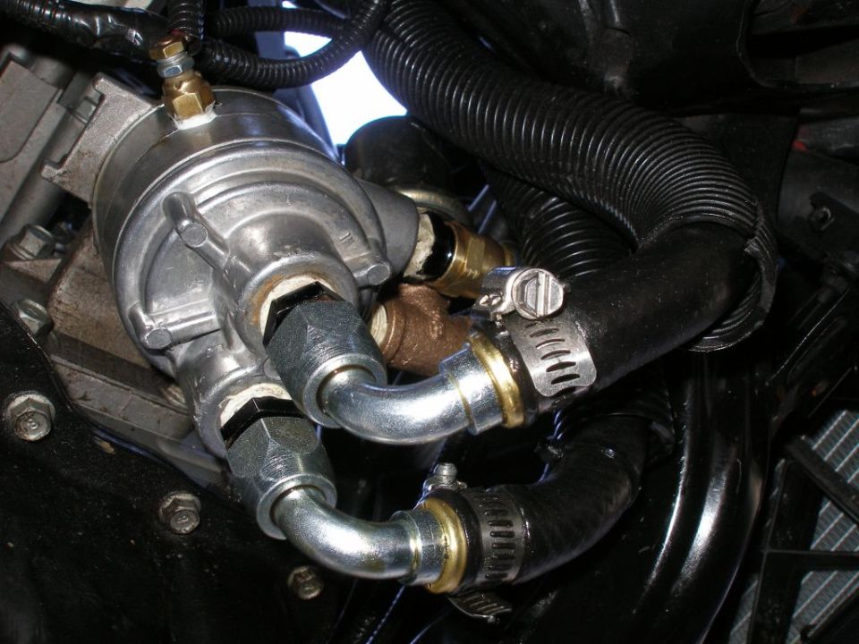 Close-up of oil cooler lines and hoses connected to a metal component