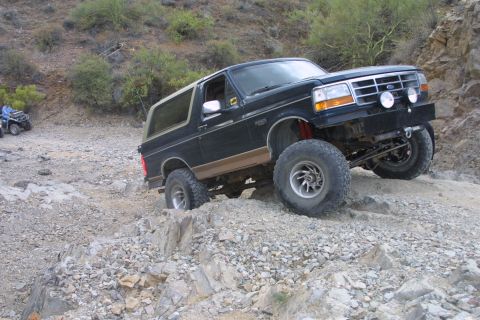 1994 Ford Bronco - This 1994 Ford Bronco navigates a challenging off-road trail with steep inclines and loose rocks.