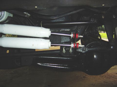 1986 Ford Bronco - Underside view of a vehicle's rear axle, showing dual shock absorbers and differential housing. The Supermotors.net logo is visible in the…