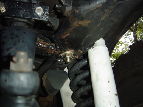 1986 Ford Bronco - Underside view of a vehicle's suspension system, focusing on the steering box bracket and related components.