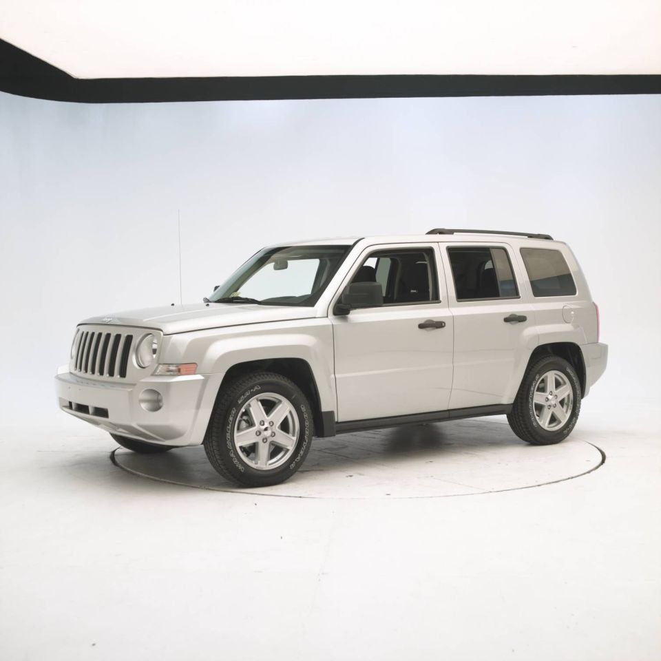 Silver SUV with a vertical grille and roof rails, viewed from the front three-quarter angle