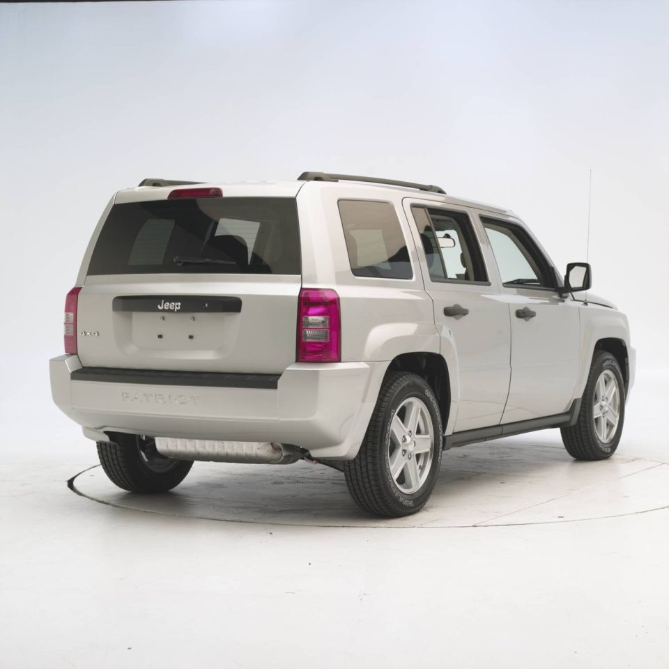 Silver Jeep Patriot SUV, rear 3/4 view. Jeep logo on tailgate, Patriot badge on bumper
