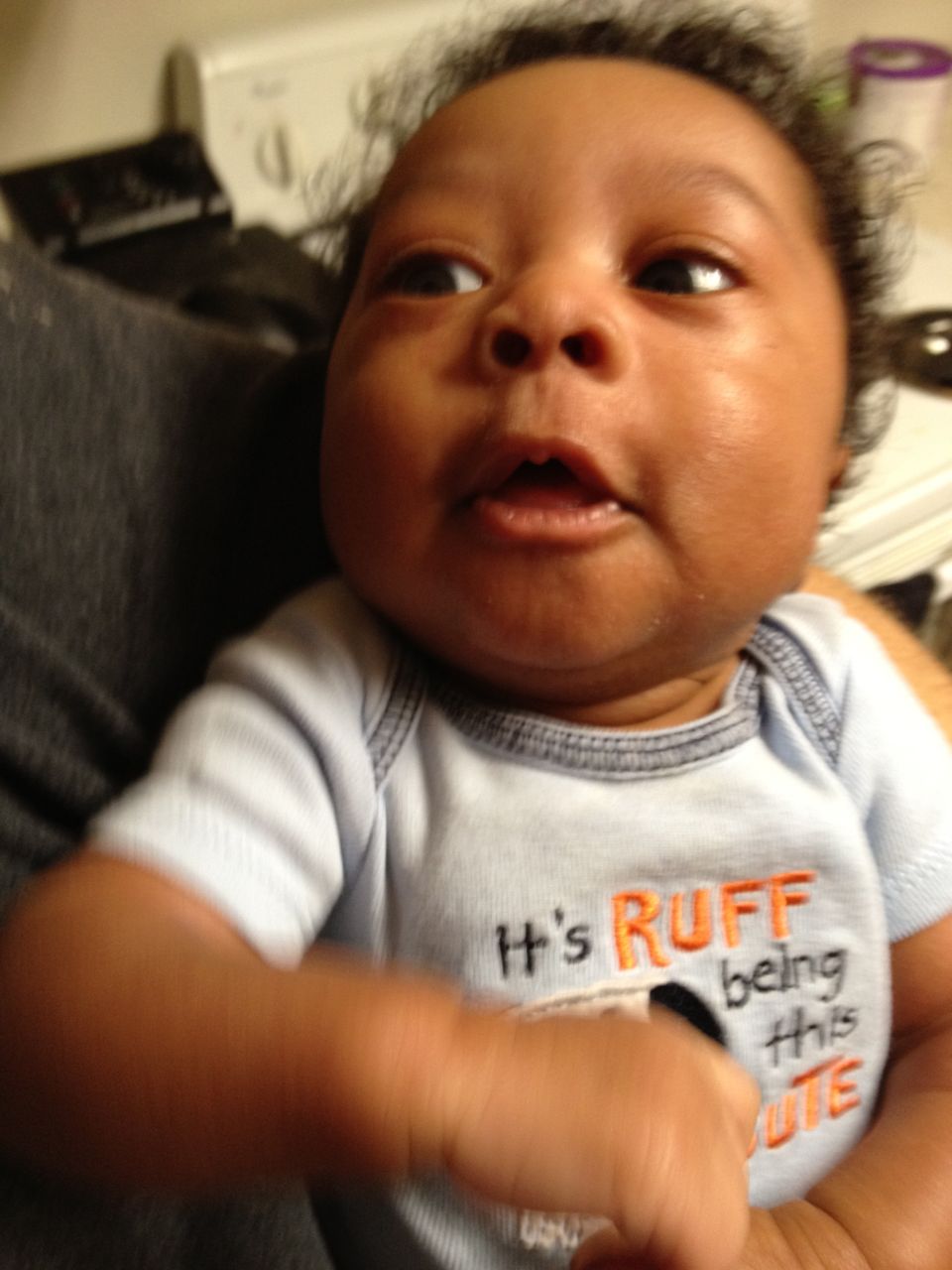 baby in a blue onesie with orange text that says 'It's RUFF being this CUTE'