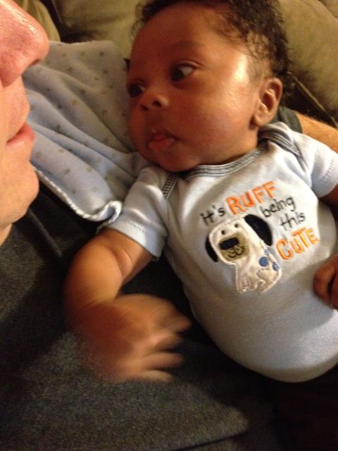 2010 Subaru Legacy - A close-up photo shows a baby looking to the side while wearing a onesie with a dog graphic.
